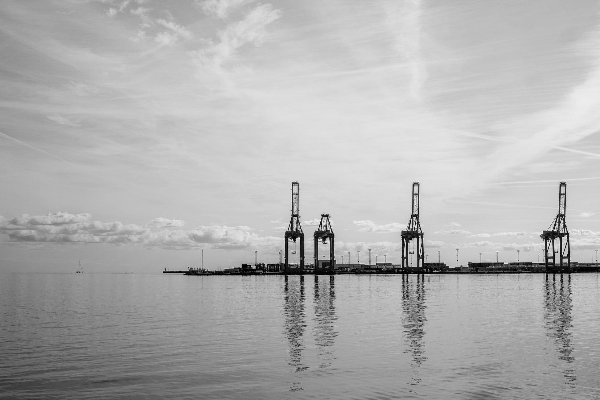 knejsende kraner ved aarhus havn reflekteret i vandet