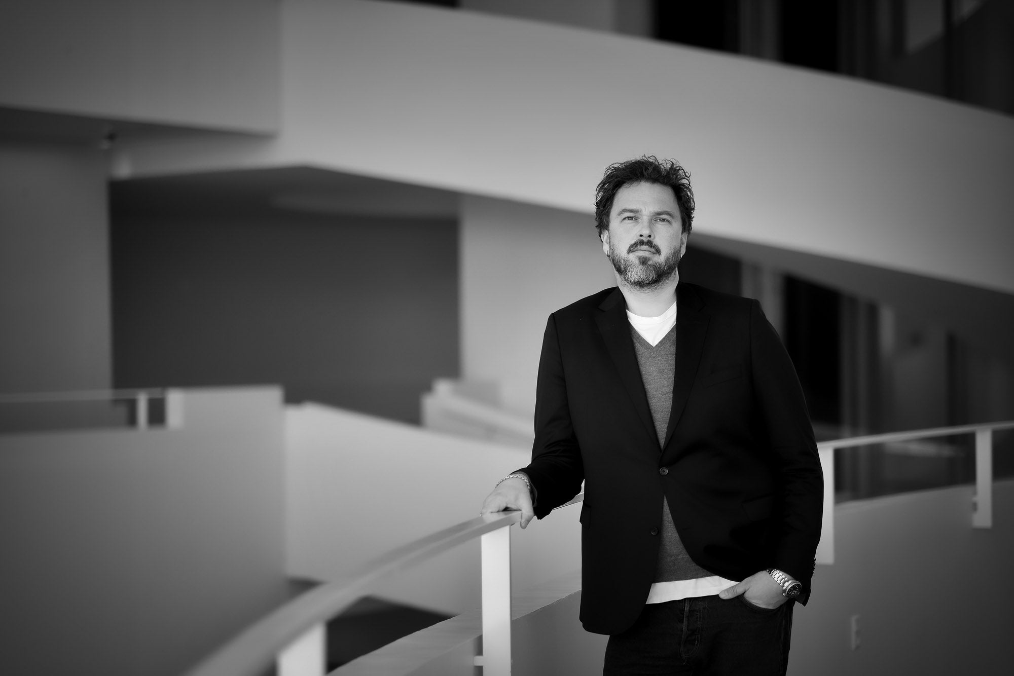 Man in a suit standing on a modern architectural staircase